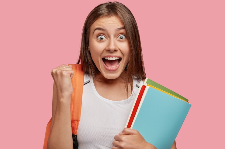 Free Photo overjoyed student posing against the pink wall