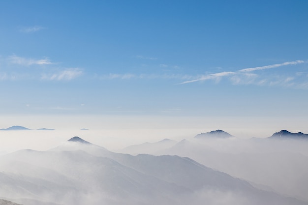 白い霧に覆われた山脈を見下ろす景色