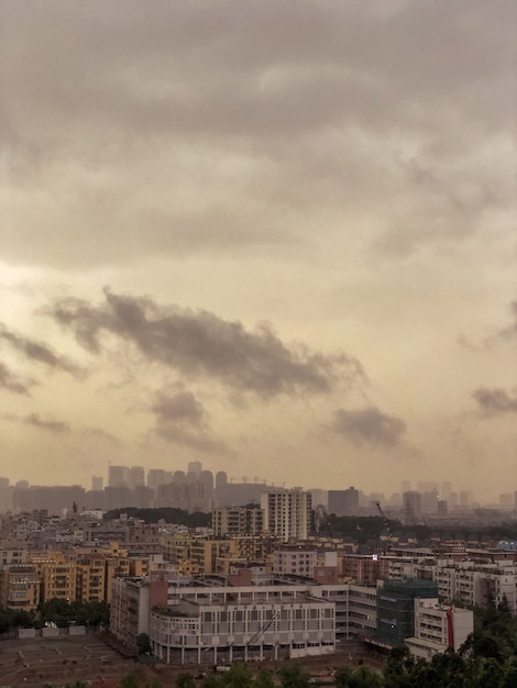 Free photo overlooking view of an urban city full of buildings with dark clouds