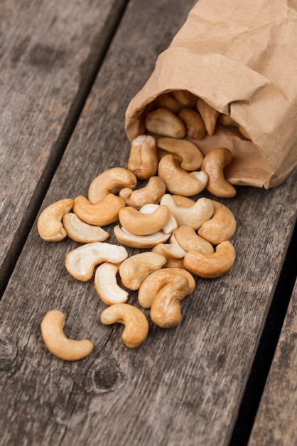 Перевёрнутый бумажный пакет, наполненный здоровыми сырыми орехами кешью