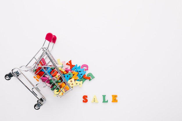 Free photo overturned shopping cart filled with letters