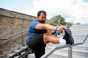 Free photo overweight man exercising on stairs outdoors