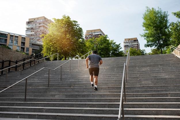 Overweight man exercising on stairs outdoors