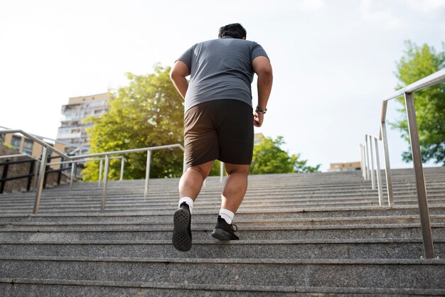 야외 계단에서 운동하는 과체중 남자