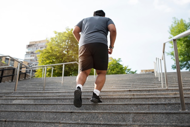 屋外の階段で運動する太りすぎの男性