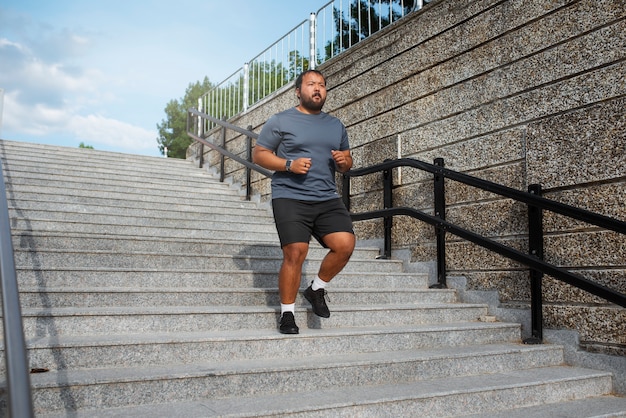 屋外の階段で運動する太りすぎの男性