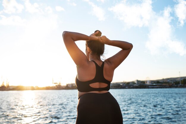 湖のそばで屋外で運動する太りすぎの女性