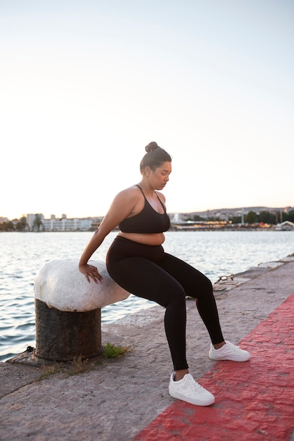 호숫가에서 야외에서 운동하는 과체중 여성