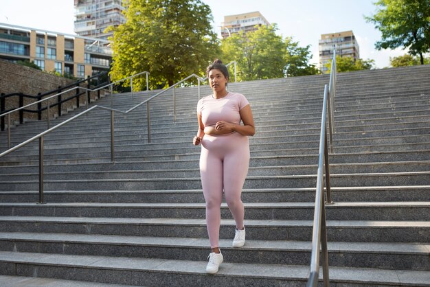 Overweight woman exercising on stairs outdoors