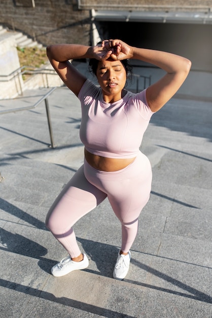 Overweight woman exercising on stairs outdoors