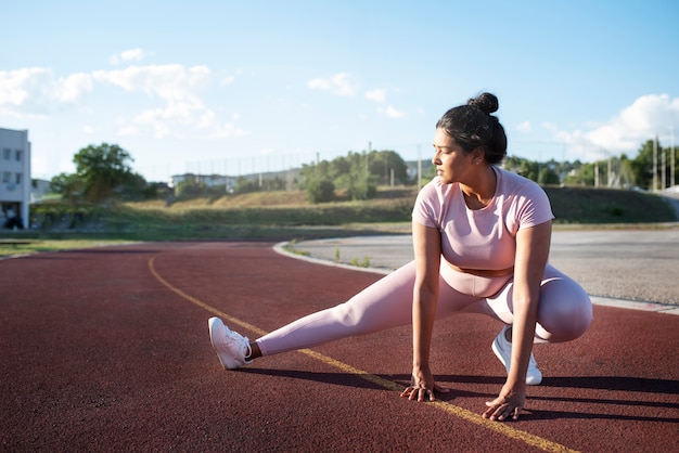 外で運動するためにウォーミングアップしている太りすぎの女性