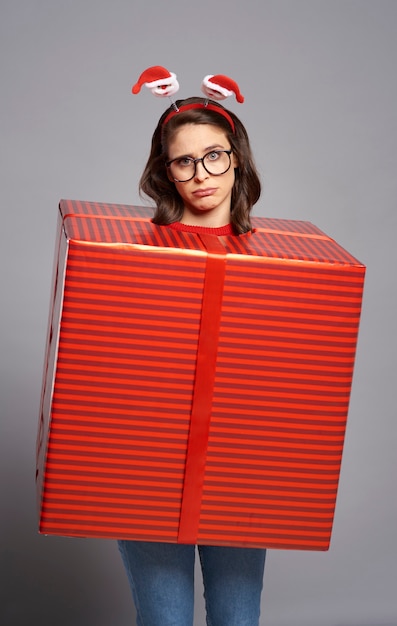 Free photo overwhelmed woman standing packed in big christmas present