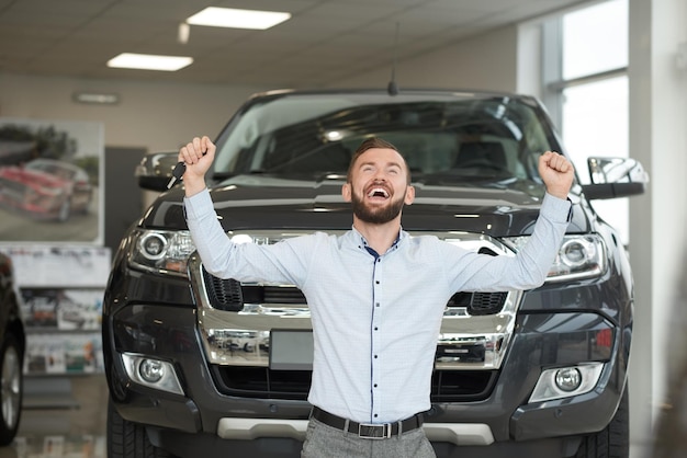 Free photo owner of expensive jeep smiling holding hands up