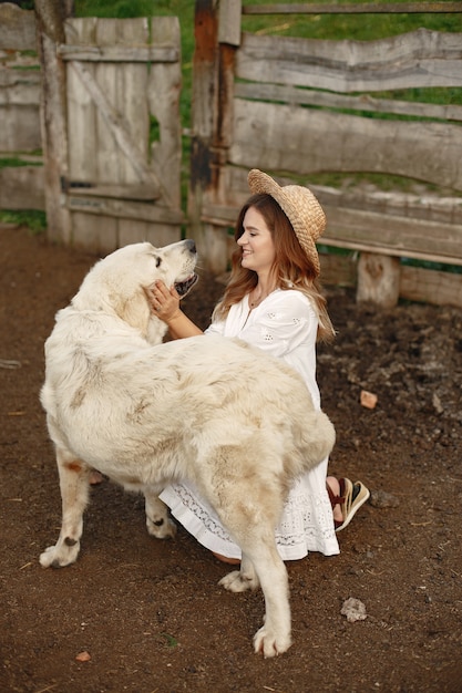 庭の飼い主とラブラドールレトリバーの犬。白いドレスを着た女性。ゴールデンレトリバー。