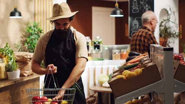 Foto gratuita il proprietario rifornisce il suo negozio di alimentari locale