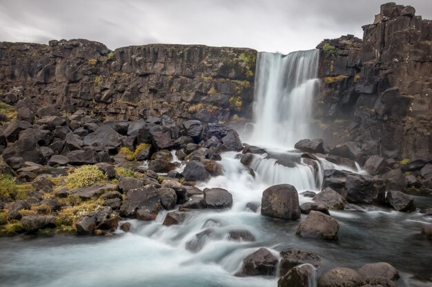 Oxararfoss waterfall in Thingvellir, Iceland under a clouded sky