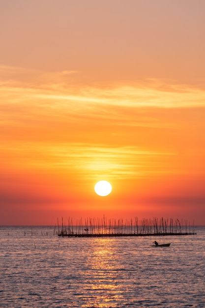 海と美しい空夕日を背景にオイスターファーム