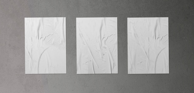 Pack of three crumpled posters on concrete surface