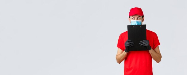 Free photo packages delivery covid quarantine transfer orders curious and excited courier in red uniform gloves...