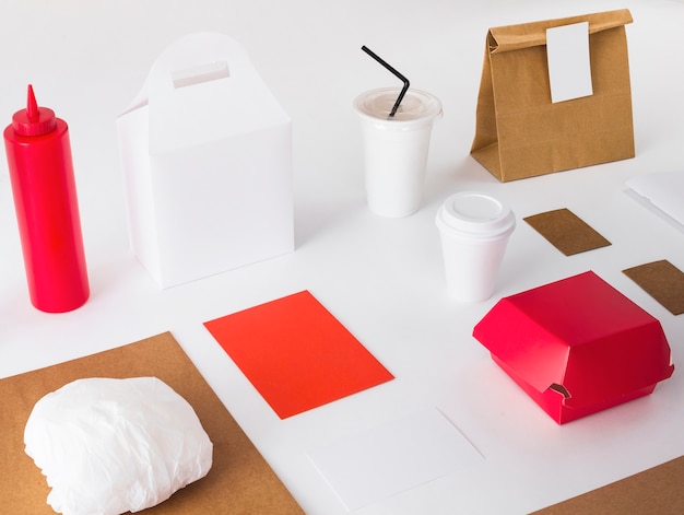 Packed food with disposal cup and sauce bottle on white background