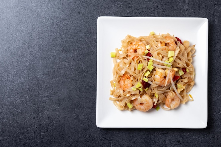 Free Photo pad thai with shrimp and vegetables on black slate background