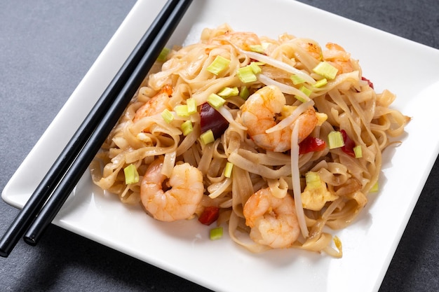 Free photo pad thai with shrimp and vegetables on black slate background