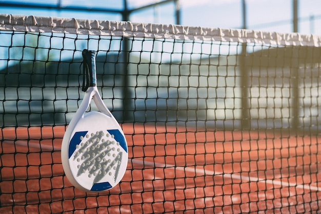 Padel blade racket hanging on the net