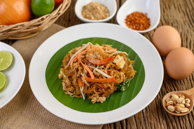 계란, 봄 양파, 나무 테이블에 양념 검은 그릇에 Padthai 새우.