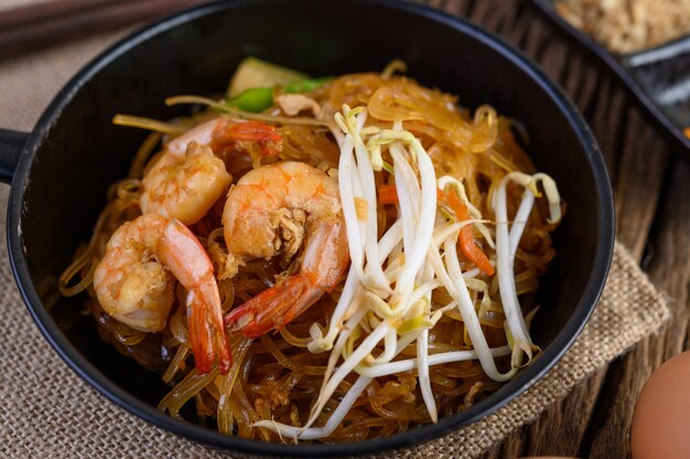 Padthai shrimp in a black bowl.