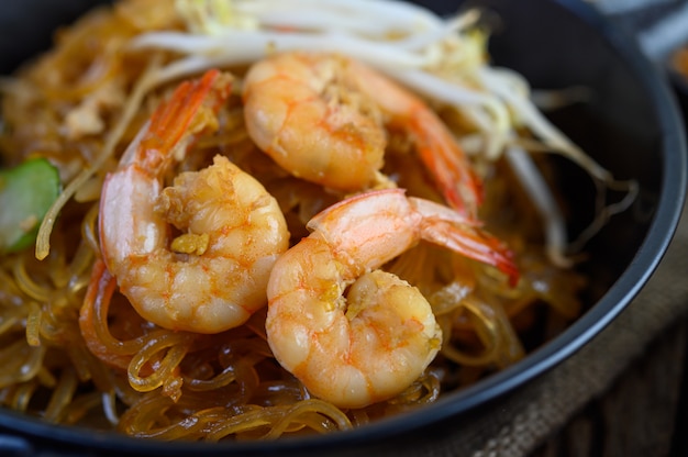 Free photo padthai shrimp in a black bowl.