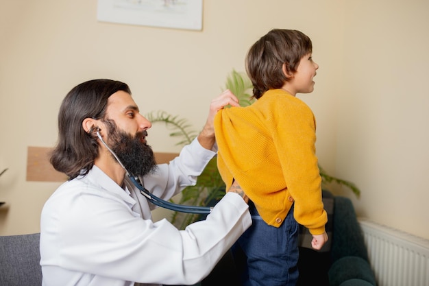 Free photo paediatrician doctor examining a child in comfortabe medical office