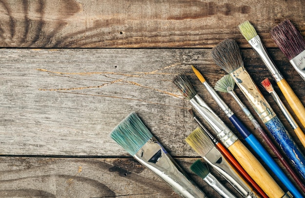 Free photo paint brushes of different sizes on a wooden background flat lay