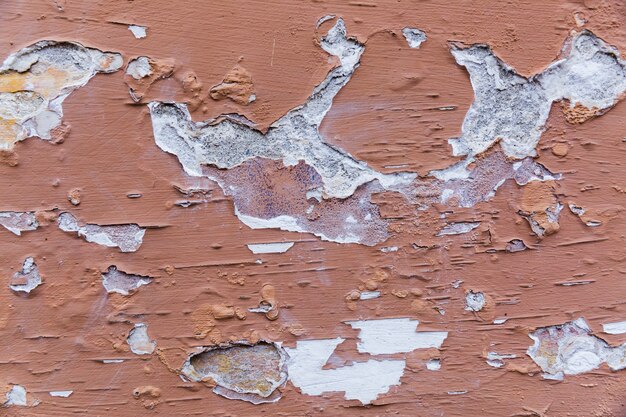Paint peeling off rough concrete wall