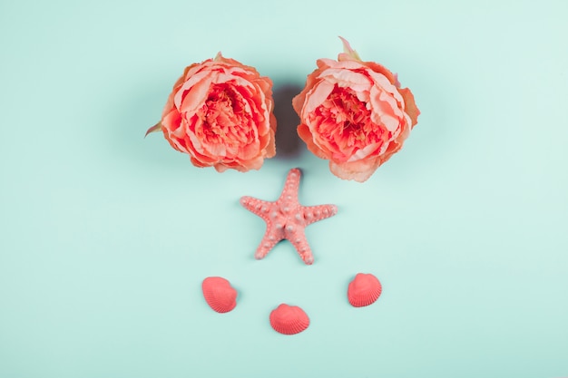 Painted coral peonies flowers; starfish and clams on mint background