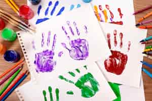 Free photo painted handprints with art equipment