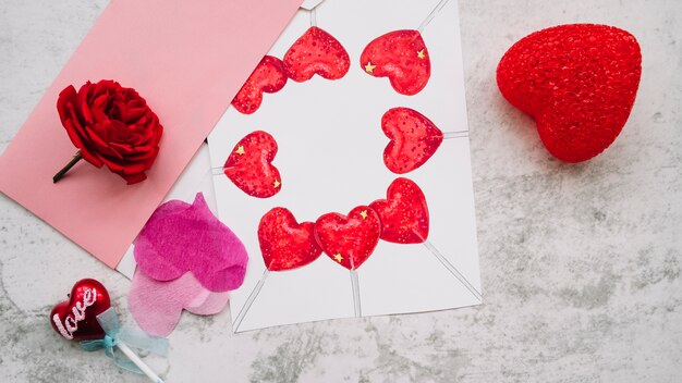 Painted and ornament hearts on paper near flower