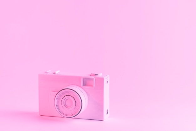 ピンクの背景に塗られたピンクのカメラ