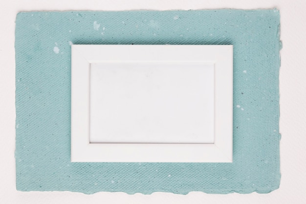 Painted white frame on textured paper over white backdrop