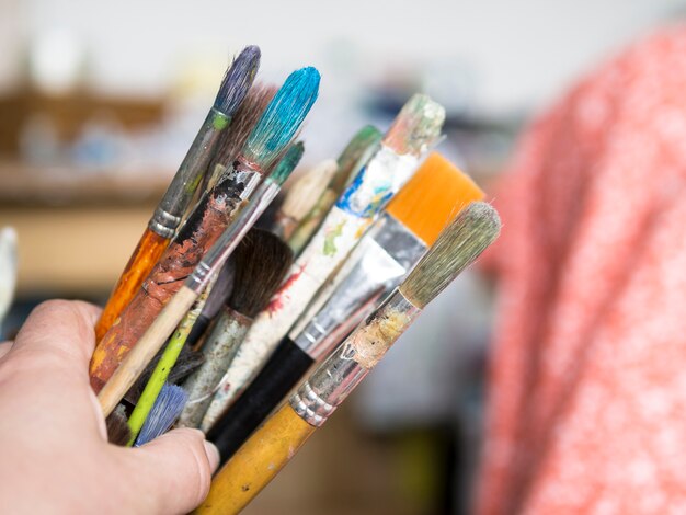 Painter holding messy brushes 