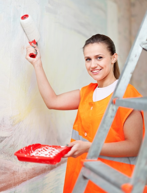 painter paints wall with roller