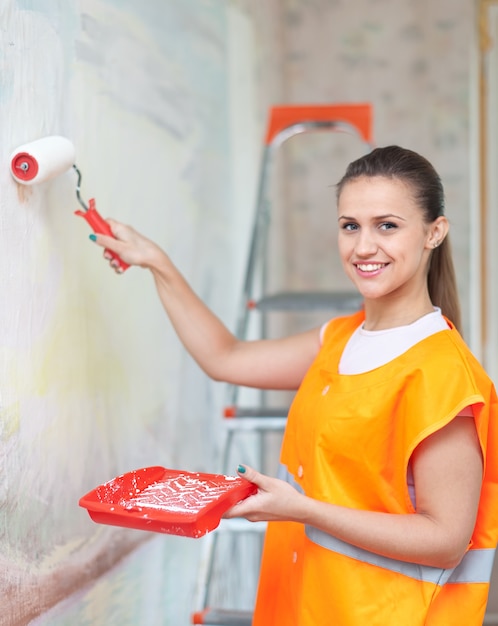 painter paints wall with roller