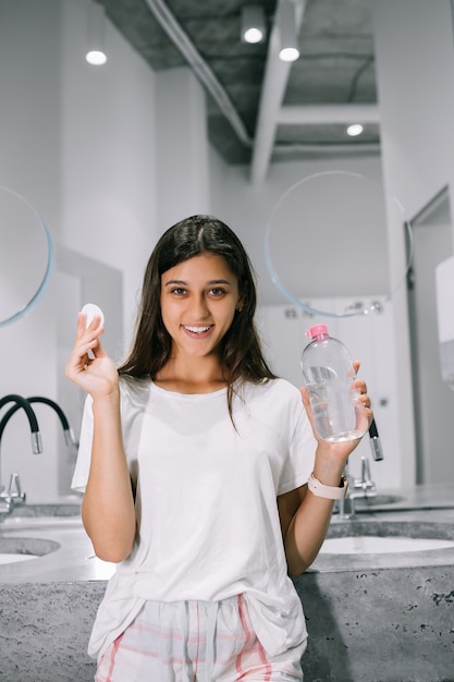 Painting of a beautiful young woman with a cotton pad in the bathroom