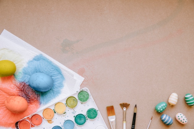 Paints and eggs placed on table