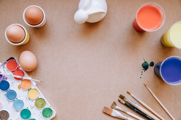 Paints, rabbit figurine, and eggs