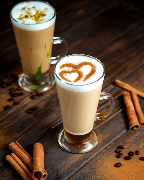 A pair of coffee drinks with milk