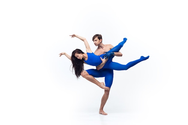 Pair of dancers in blue clothes dancing in the studio