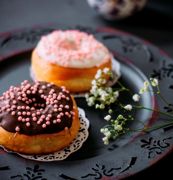 A pair of donuts with chocolate cream on top