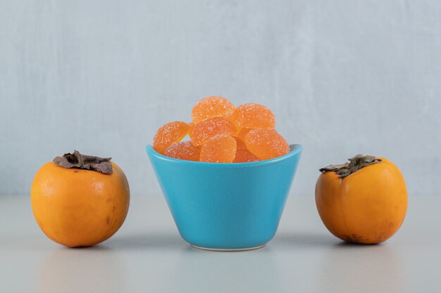 Pair of fresh persimmons with orange marmalades .