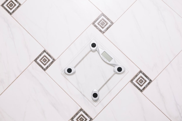 Free photo pair of scales on bathroom floor