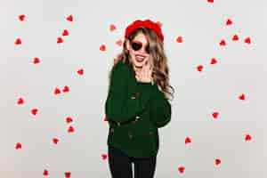 Free photo pale young woman with bright makeup laughing on white wall